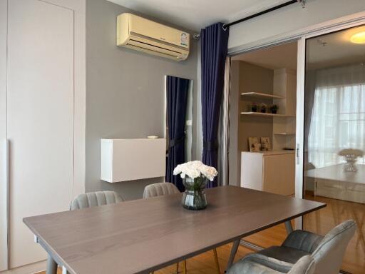 Modern dining area with table, air conditioner, and curtains