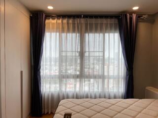 Bedroom with large window and curtains