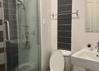 Modern bathroom with glass shower, toilet, and sink