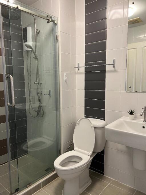 Modern bathroom with glass shower, toilet, and sink