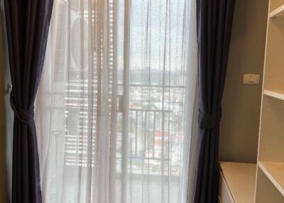 Bedroom with curtains and view of the city