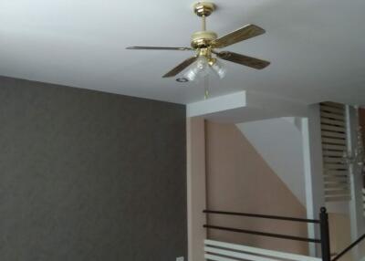 Living room with ceiling fan and staircase
