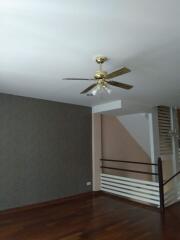 Living room with ceiling fan and staircase