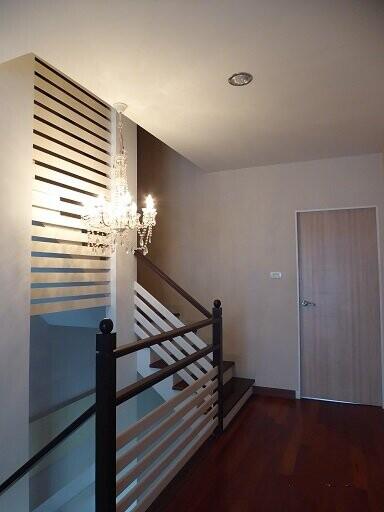 Staircase with wooden steps and modern chandelier