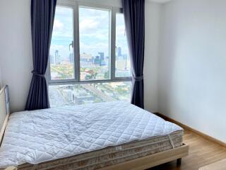 Bright bedroom with large windows and city view