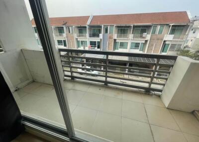 Balcony view with patio area and neighboring buildings