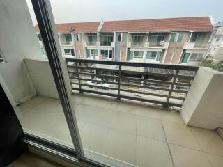 Balcony view with patio area and neighboring buildings