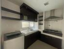 Modern kitchen with built-in cabinets, gas stove, sink, washing machine, and window