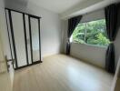 empty bedroom with large window and wardrobe