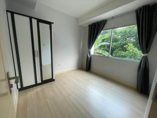 empty bedroom with large window and wardrobe