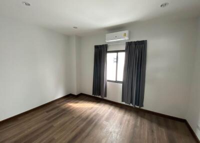 Empty bedroom with air conditioning and window with curtains
