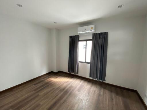 Empty bedroom with air conditioning and window with curtains