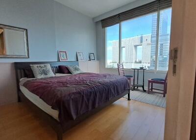Modern bedroom with large window showing city view