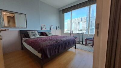 Modern bedroom with large window showing city view