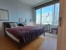 Modern bedroom with large window showing city view