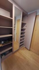 Closet area with shelves and mirrored door