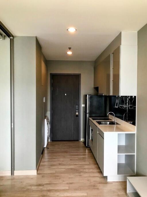 Modern kitchen with wooden flooring and entry door