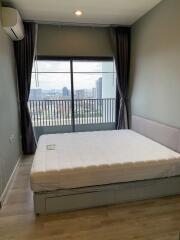 Bedroom with a large window and city view