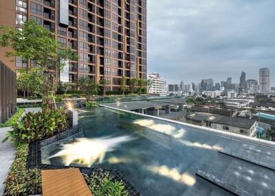 Modern high-rise residential building with rooftop infinity pool offering city skyline views