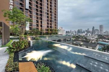 Modern high-rise residential building with rooftop infinity pool offering city skyline views