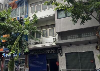 Street view of a multi-story residential building with trees