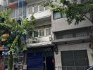 Street view of a multi-story residential building with trees