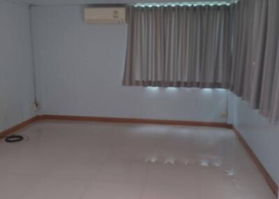 Empty room with tiled floor, air conditioner, and curtains