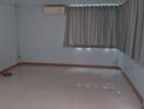 Empty room with tiled floor, air conditioner, and curtains