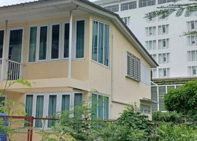 Exterior view of a two-story building with windows and garden area