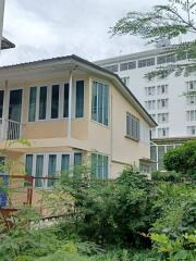 Exterior view of a two-story building with windows and garden area