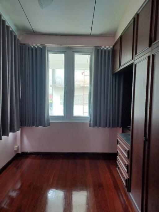 Bedroom with window and built-in wardrobe