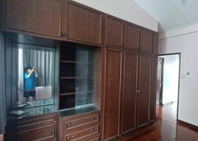 Bedroom with large wooden wardrobe and vanity mirror