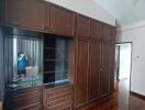 Bedroom with large wooden wardrobe and vanity mirror