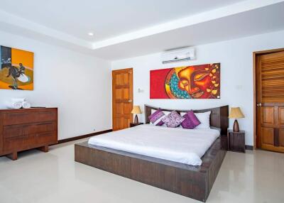 Spacious and modern bedroom with artistic decor and wooden furniture