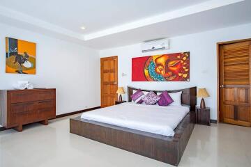 Spacious and modern bedroom with artistic decor and wooden furniture