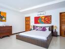 Spacious and modern bedroom with artistic decor and wooden furniture