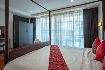 Bedroom with large window and four-poster bed