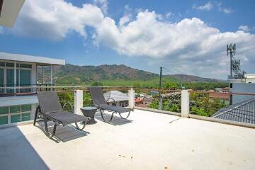 Terrace with lounge chairs and view of mountains