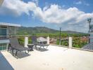 Terrace with lounge chairs and view of mountains