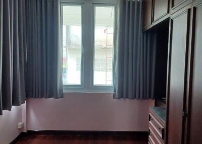 Bedroom with wooden flooring and large window