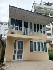 Two-story residential building with multiple windows and a small balcony