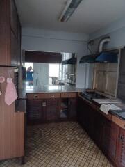 Kitchen with dark wooden cabinets, stainless steel countertop, and mirrored backsplash