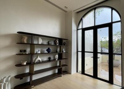 Spacious living room with large arched window and modern shelving