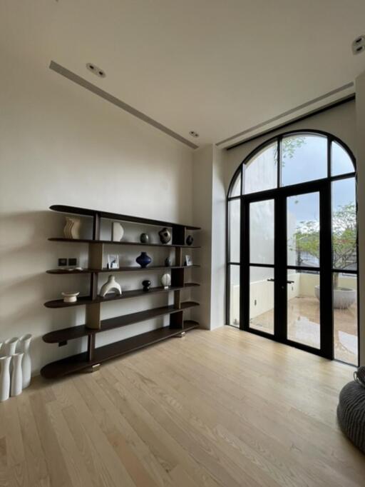 Spacious living room with large arched window and modern shelving