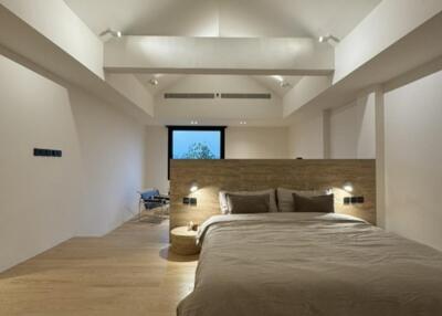 Spacious modern bedroom with wooden floor and high ceiling