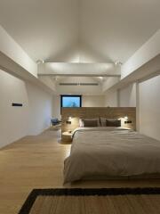 Spacious modern bedroom with wooden floor and high ceiling