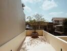 Spacious balcony with potted tree and neighborhood view