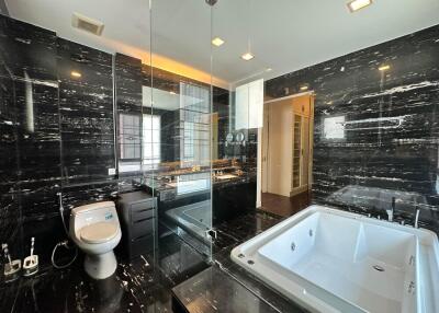 Luxurious bathroom with black marble walls and a glass-enclosed shower