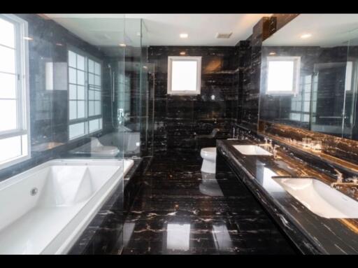 Modern black marble bathroom with bathtub and dual sinks