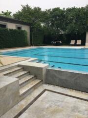 Swimming pool area with steps and lounge chairs